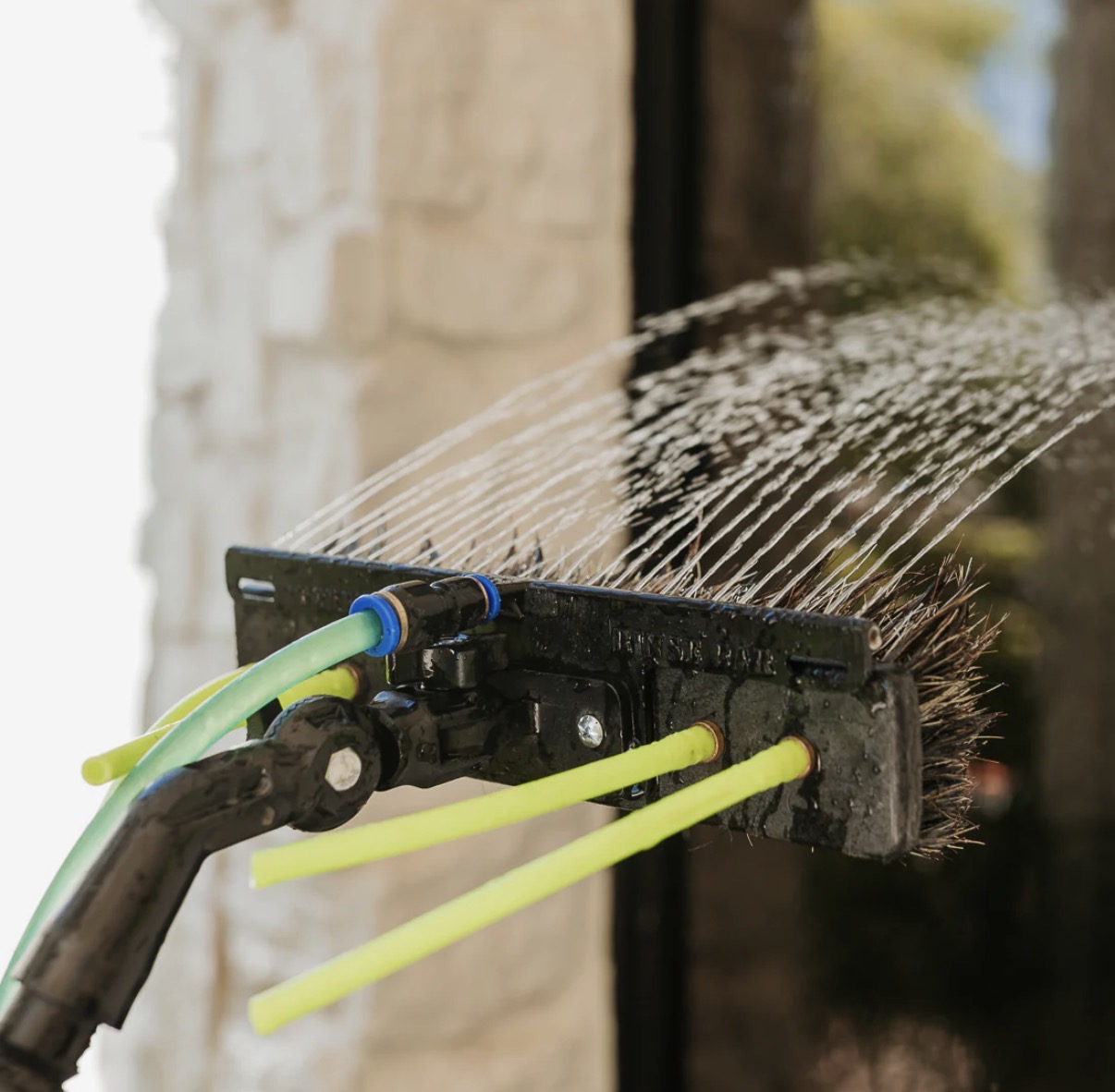 Close-up of water-fed brush rinsing a window streak-free