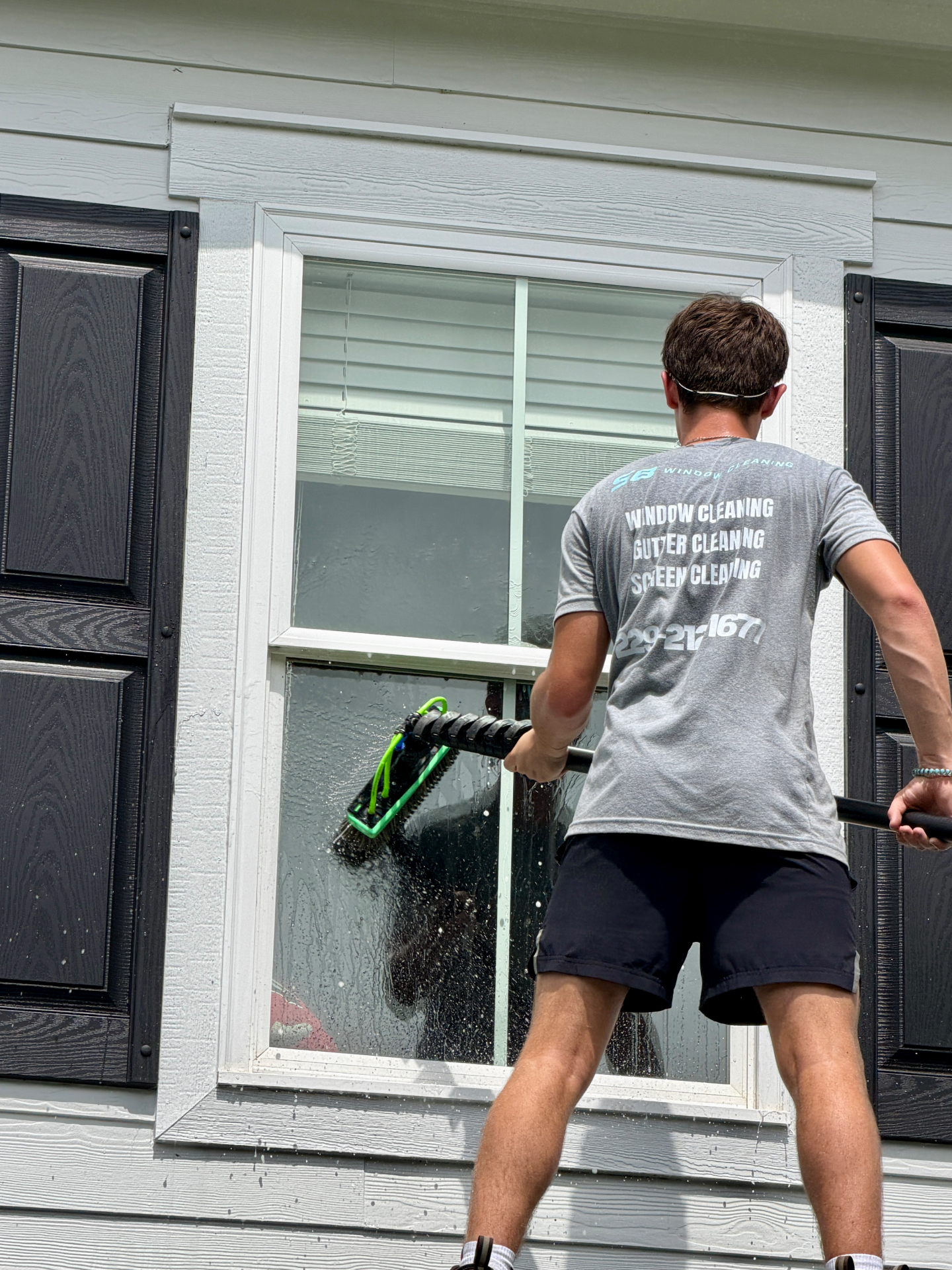 Window cleaner using a water-fed pole on a Valdosta commercial building